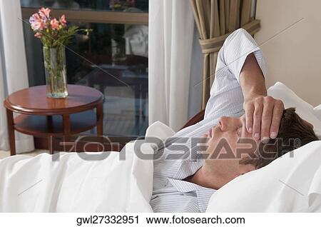 Man lying in a hospital bed View Large Photo Image Stock Image - Man lying in a hospital bed. Fotosearch