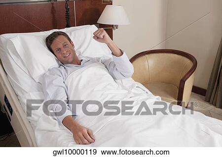 Stock Photo - Man lying in a hospital bed. Fotosearch