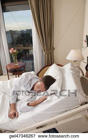 Man lying in a hospital bed View Large Photo Image Stock Photo - Man lying in a hospital bed. Fotosearch