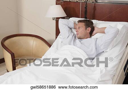 Man lying in a hospital bed View Large Photo Image Stock Photograph - Man lying in a hospital bed. Fotosearch