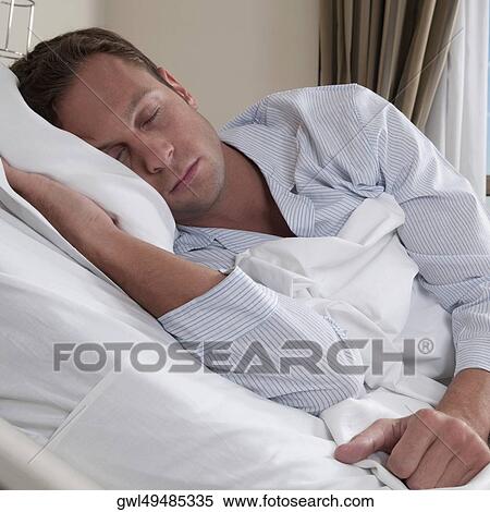 Man lying in a hospital bed View Large Photo Image Stock Photography - Man lying in a hospital bed. Fotosearch