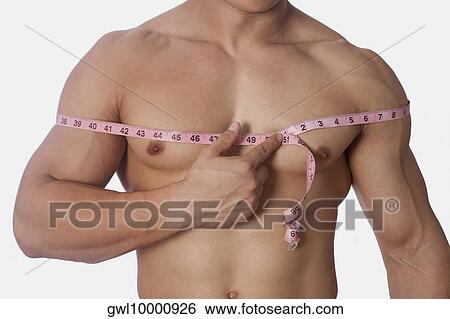 Man measuring his chest with a tape measure View Large Photo Image Stock Photograph - Man measuring his chest with a tape measure. Fotosearch