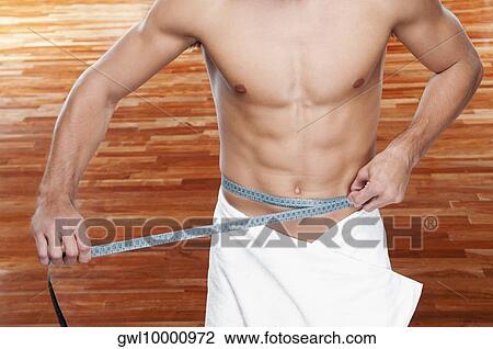 Man measuring his waist with a tape measure View Large Photo Image Stock Image - Man measuring his waist with a tape measure. Fotosearch