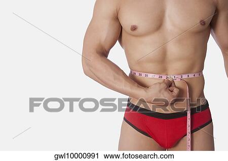 Man measuring his waist with a tape measure View Large Photo Image Stock Image - Man measuring his waist with a tape measure. Fotosearch