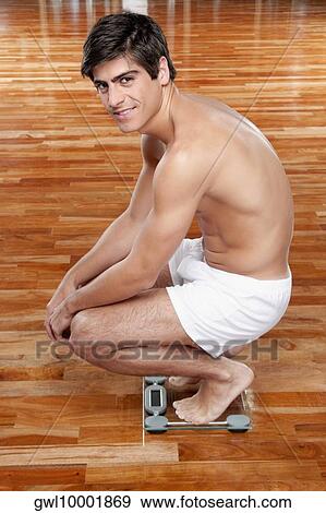Man measuring his weight on a weighing scale View Large Photo Image Stock Photo - Man measuring his weight on a weighing scale. Fotosearch