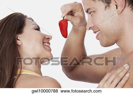 Man offering a red chili pepper to woman View Large Photo Image Stock Photo - Man offering a red chili pepper to woman. Fotosearch