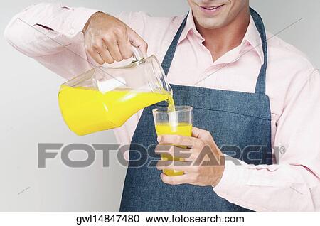 Man pouring orange juice in a glass View Large Photo Image Stock Image - Man pouring orange juice in a glass. Fotosearch