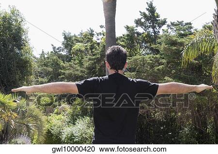 Stock Image - Man practicing yoga in a park. Fotosearch