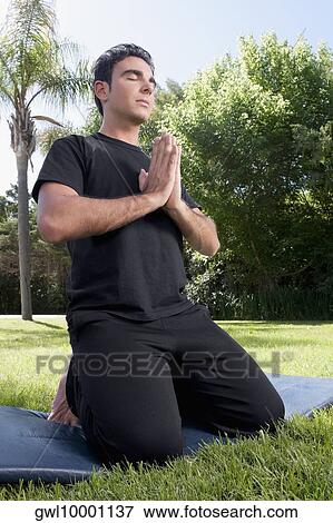 Man practicing yoga in a park View Large Photo Image Stock Photo - Man practicing yoga in a park. Fotosearch