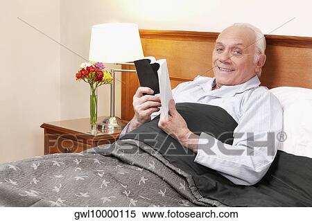 Man reading a book in nursing home and smiling View Large Photo Image Stock Photography - Man reading a book in nursing home and smiling. Fotosearch