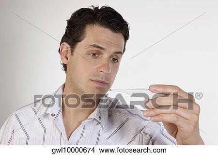 Man reading a thermometer View Large Photo Image Picture - Man reading a thermometer. Fotosearch