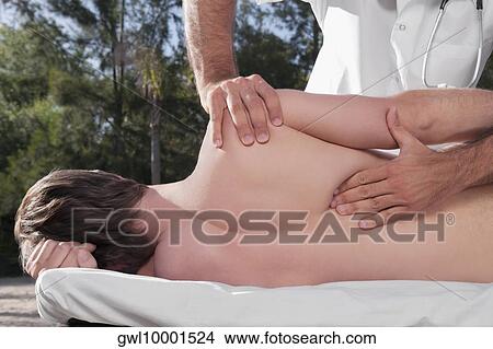 Man receiving a back massage from a massage therapist View Large Photo Image Picture - Man receiving a back massage from a massage therapist. Fotosearch