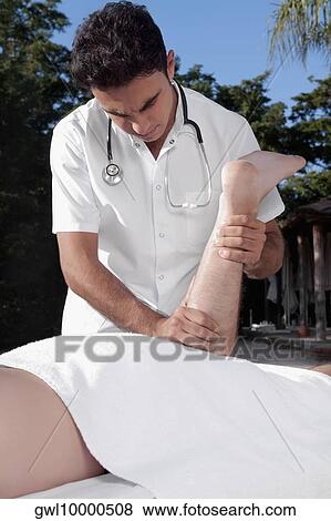 Man receiving a massage from a massage therapist View Large Photo Image Stock Photo - Man receiving a massage from a massage therapist. Fotosearch