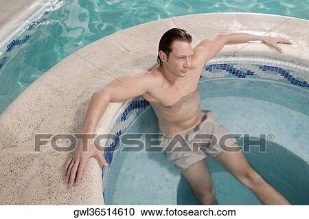 Stock Image - Man relaxing in a hot tub. Fotosearch