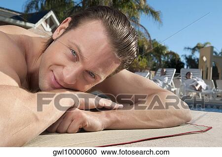 Man resting at the poolside View Large Photo Image Stock Image - Man resting at the poolside. Fotosearch