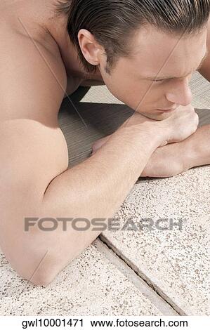 Man resting at the poolside View Large Photo Image Stock Image - Man resting at the poolside. Fotosearch