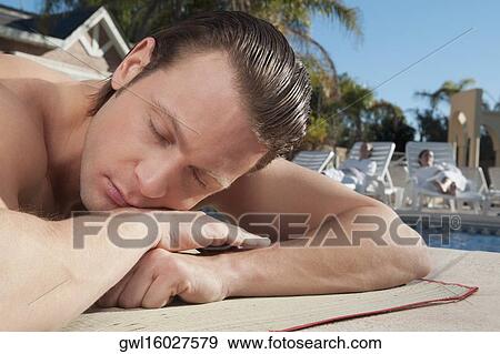 Man resting at the poolside View Large Photo Image Stock Photo - Man resting at the poolside. Fotosearch