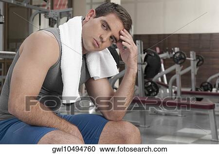 Man rubbing his forehead in a gym View Large Photo Image Stock Image - Man rubbing his forehead in a gym. Fotosearch