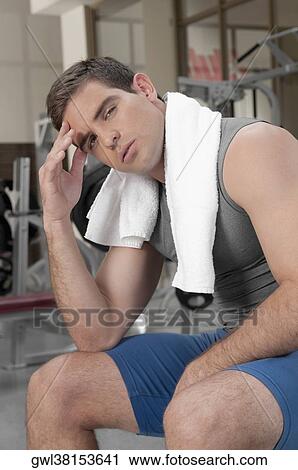 Man rubbing his forehead in a gym View Large Photo Image Stock Image - Man rubbing his forehead in a gym. Fotosearch