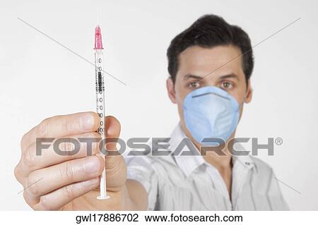Man showing a syringe View Large Photo Image Stock Image - Man showing a syringe. Fotosearch