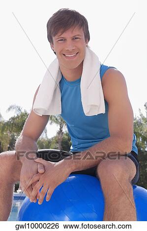Man sitting on a fitness ball and smiling View Large Photo Image Stock Photograph - Man sitting on a fitness ball and smiling. Fotosearch