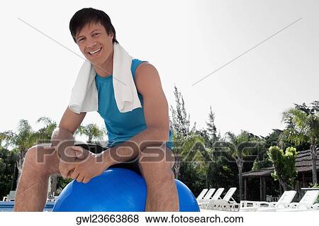Man sitting on a fitness ball at the poolside View Large Photo Image Stock Photo - Man sitting on a fitness ball at the poolside. Fotosearch