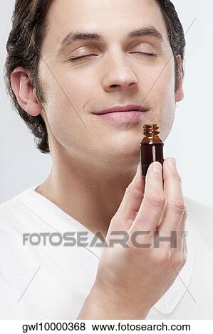 Man smelling aromatherapy oil View Large Photo Image Stock Photo - Man smelling aromatherapy oil. Fotosearch