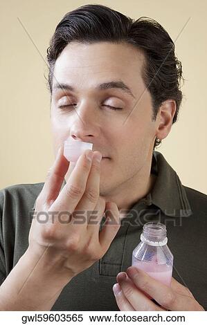 Man smelling medicine syrup View Large Photo Image Stock Photography - Man smelling medicine syrup. Fotosearch