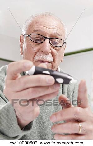 Man testing his blood sugar level View Large Photo Image Stock Photo - Man testing his blood sugar level. Fotosearch
