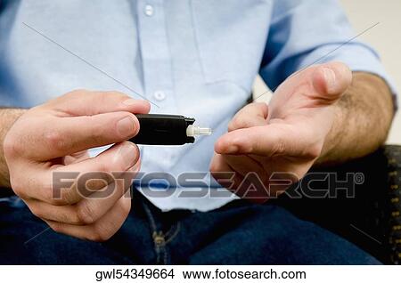 Man testing his blood sugar View Large Photo Image Picture - Man testing his blood sugar. Fotosearch