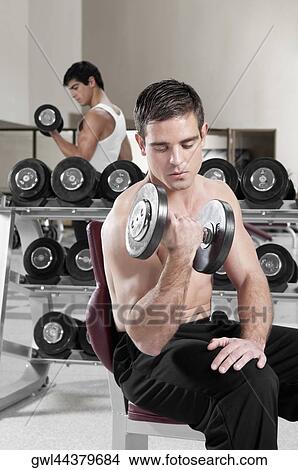 Picture - Men lifting weights at gym. Fotosearch