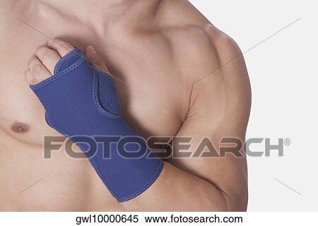 Stock Photography - Mid section view of a bare chested man wearing a wrist brace. Fotosearch