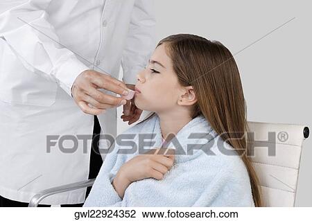 Mid section view of a doctor giving medicine to a girl View Large Photo Image Stock Image - Mid section view of a doctor giving medicine to a girl. Fotosearch