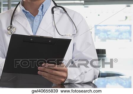 Mid section view of a doctor holding a clipboard View Large Photo Image Stock Photo - Mid section view of a doctor holding a clipboard. Fotosearch