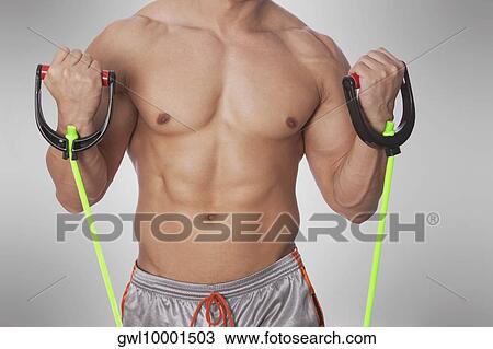 Mid section view of a man exercising with resistance band View Large Photo Image Stock Image - Mid section view of a man exercising with resistance band. Fotosearch