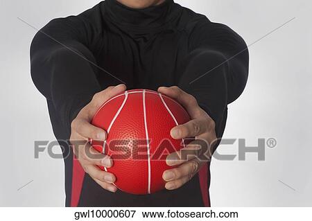 Stock Photo - Mid section view of a man exercising with a medicine ball. Fotosearch
