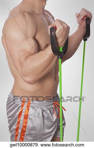 Mid section view of a man exercising with resistance band View Large Photo Image Stock Photo - Mid section view of a man exercising with resistance band. Fotosearch