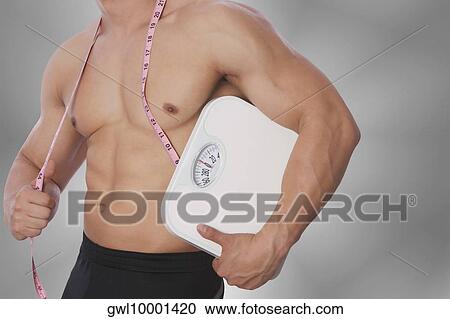 Mid section view of a man holding a bathroom scale View Large Photo Image Stock Image - Mid section view of a man holding a bathroom scale. Fotosearch