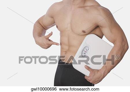 Mid section view of a man holding a bathroom scale and showing his abdomen View Large Photo Image Stock Photograph - Mid section view of a man holding a bathroom scale and showing his abdomen. Fotosearch