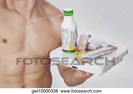 Mid section view of a man holding food supplements View Large Photo Image Stock Photo - Mid section view of a man holding food supplements. Fotosearch