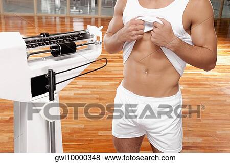 Mid section view of a man showing his waist View Large Photo Image Stock Photo - Mid section view of a man showing his waist. Fotosearch