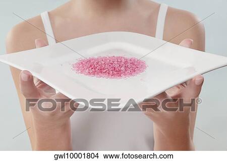 Mid section view of a woman holding a tray of bath crystals View Large Photo Image Picture - Mid section view of a woman holding a tray of bath crystals. Fotosearch