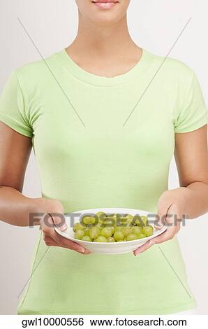 Stock Photograph - Mid section view of a woman holding a bowl of grapes. Fotosearch