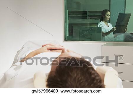 Nurse examining MRI scan of a patient View Large Photo Image Stock Photo - Nurse examining MRI scan of a patient. Fotosearch