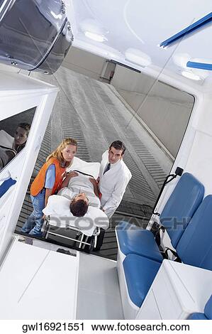 Paramedics leading a patient on a gurney into an ambulance View Large Photo Image Stock Image - Paramedics leading a patient on a gurney into an ambulance. Fotosearch