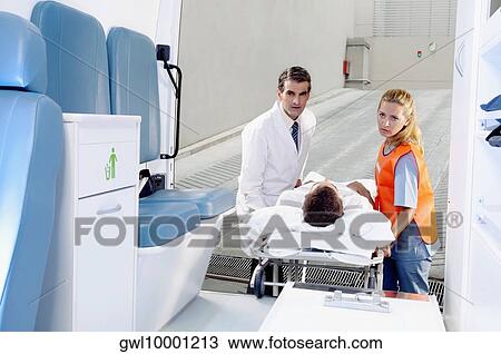 Paramedics pushing a patient on a gurney from an ambulance View Large Photo Image Stock Image - Paramedics pushing a patient on a gurney from an ambulance. Fotosearch