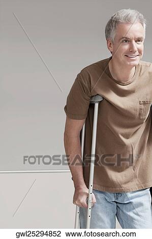 Stock Image - Patient walking with the help of crutches. Fotosearch