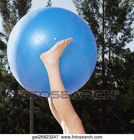 Person's legs holding a fitness ball View Large Photo Image Stock Photo - Person's legs holding a fitness ball. Fotosearch