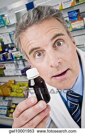Pharmacist showing a medicine bottle View Large Photo Image Stock Image - Pharmacist showing a medicine bottle. Fotosearch