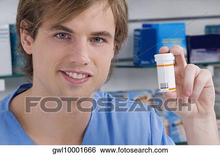 Pharmacist showing a medicine bottle and smiling View Large Photo Image Stock Photograph - Pharmacist showing a medicine bottle and smiling. Fotosearch